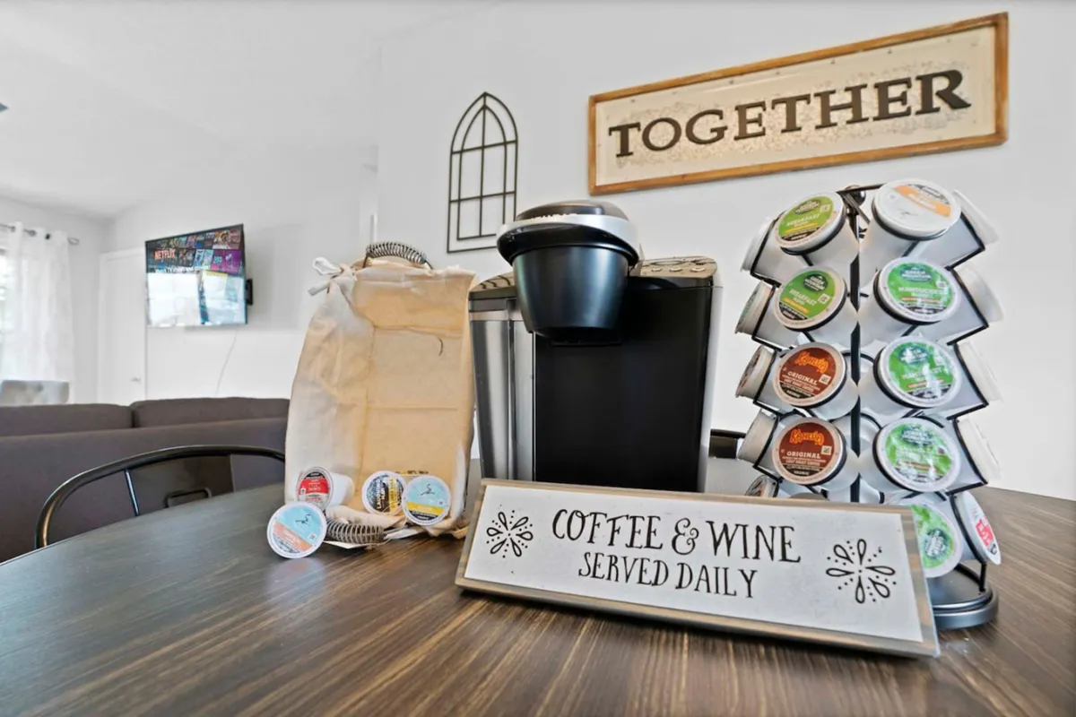A coffee station equipped with a modern coffee maker, an assortment of coffee pods, and welcoming signage. The arrangement suggests ease and efficiency for busy mornings or pre-meeting routines.